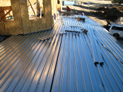 Corrugated Metal Sheeting is Screwed to Steel Beams