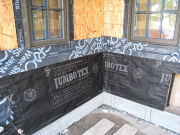 Battered walls wrapped with paper and flashings