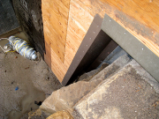 Metal flashing between retaining and battered wall