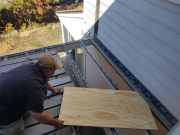 Carlos installing waterproof membrane on floor joists