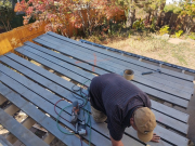 Carlos installing waterproof membrane on floor joists