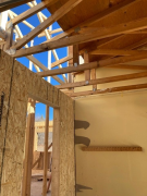 New garage wall & existing trusses before repair