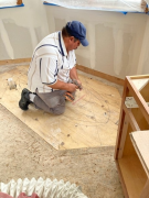 Carlos screwing subfloor for tile installation