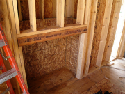 Insulation barrier behind fireplace
