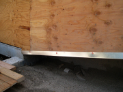 Flashing protecting bottom of battered walls plywood